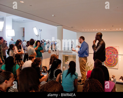 Spiegare presenta una guida (maglietta blu) porta i visitatori attraverso il Museo di Arte Moderna di New York City. Foto Stock