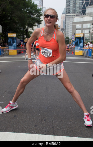 Una gravidanza Paula Radcliffe (GBR) stretching prima di iniziare il 2010 New York Mini 10K. Foto Stock