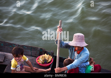 Commerciante donna con i suoi figli in una barca vicino a Siem Reap Foto Stock