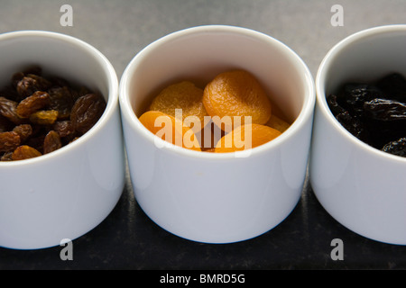 Frutta secca, uva passa, albicocche, prugne in bianco tre vasi di ceramica Foto Stock