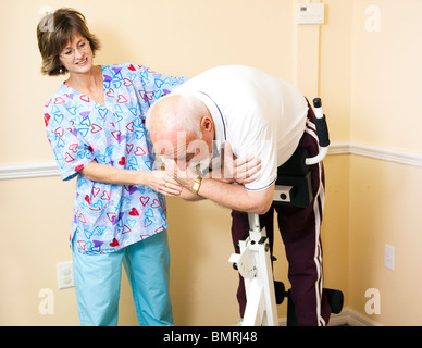 Terapista fisico in un ufficio di chiropratici aiutare un paziente a tratto il suo dorso su una sedia romana. Foto Stock