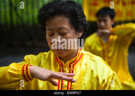 Donna pratica di Falun Gong, una forma di meditazione cinese di esercizi in una posizione nota come "inforcing poteri soprannaturali'. Foto Stock