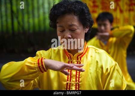 Donna pratica di Falun Gong, una forma di meditazione cinese di esercizi in una posizione nota come "inforcing poteri soprannaturali'. Foto Stock