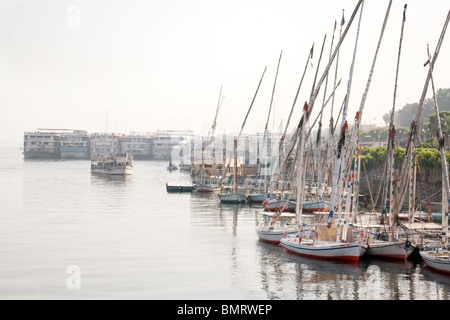 Feluche e navi da crociera legato sulle rive del fiume Nilo a Luxor, Egitto Foto Stock