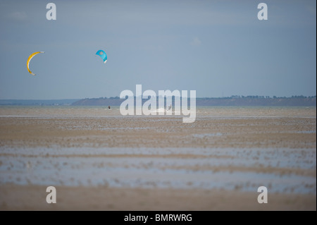 Due kite surfers giocando sulla marea dell'estuario del Tamigi a Maplin Sands, Essex. Foto Stock