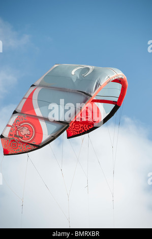 Il kite Kitesurf aleggia nel vento contro il cielo blu e nuvole bianche. Foto Stock