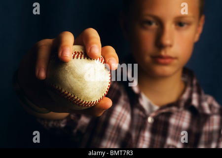 Un ragazzo tenendo un baseball Foto Stock