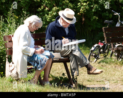 Due artisti seduto su una panchina nel parco, Devon, Regno Unito Foto Stock