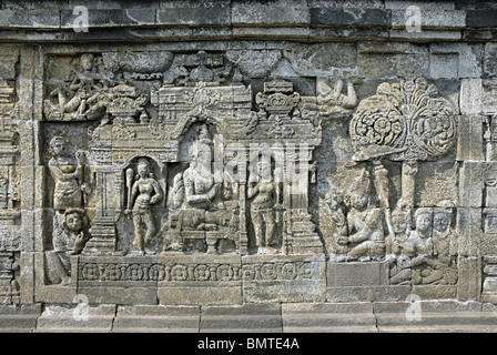 Indonesia-Java-Borobudur, 4 terrazza/galleria, re seduto sul trono con gli assistenti femminili e devoti di fronte. Foto Stock