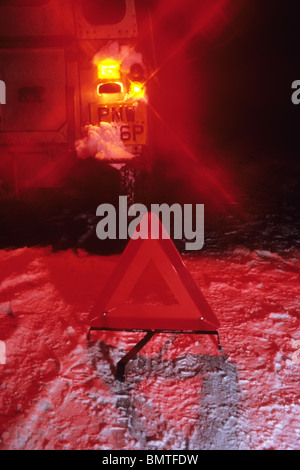 Triangolo di segnalazione di veicolo su strada di campagna nel profondo neve invernale di notte nei pressi di Leeds Yorkshire Regno Unito Foto Stock