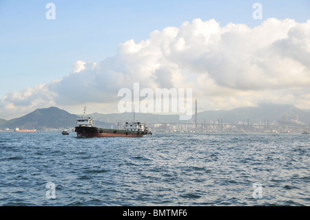 Blue sky view vuoti di portarinfuse barge, attraverso il Victoria Harbour da Kennedy Town a Kowloon Tsing Ma Bridge, Hong Kong Foto Stock