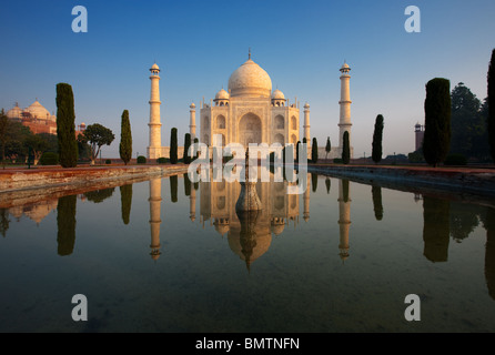 Il Taj Mahal si illumina splendidamente a sunrise mentre si riflette in una calma fontana d'acqua. Foto Stock