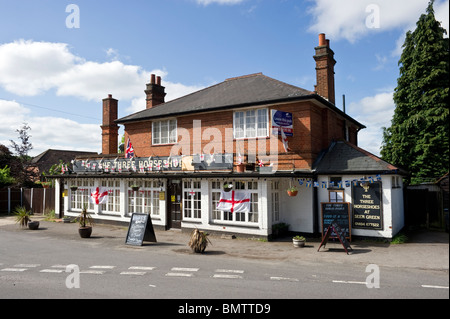 I tre ferri di cavallo è un villaggio locale public house in Seer Green, Bucks, Regno Unito decorate con Inghilterra bandiere. Foto Stock