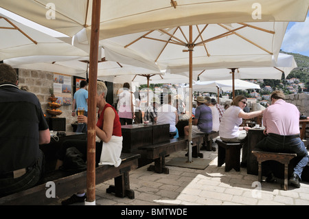 Il turista a godere di un drink rilassante presso una caffetteria sulle mura della città vecchia di Dubrovnik Foto Stock