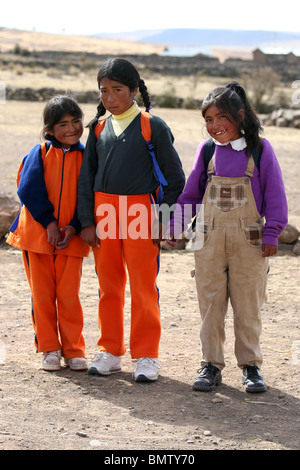 Scolari andare a scuola a piedi da Sillustani, Lago Umayo vicino a Puno, Perù. Foto Stock