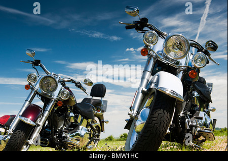 Harley Davidson Moto in un campo contro un luminoso blu cielo nuvoloso in Inghilterra Foto Stock