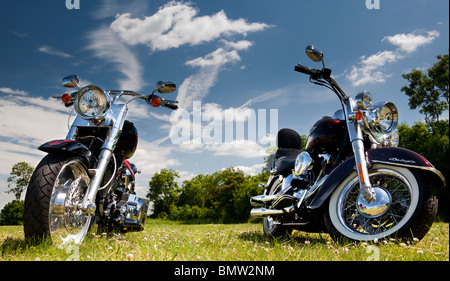 Harley Davidson Moto in un campo contro un luminoso blu cielo nuvoloso in Inghilterra Foto Stock