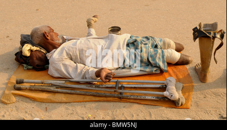 Disabilitato mendicante , tempio di Pashupatinath, sacro fiume Bagmati , Kathmandu, Nepal Foto Stock