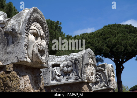 Tre maschere feroce, scolpiti in pietra ad Ostia Antica, vicino Roma, Italia Foto Stock