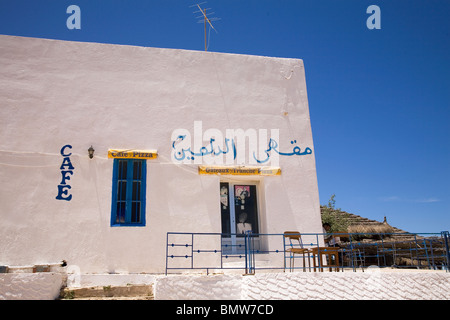 Una caffetteria dipinte di bianco si staglia contro un cielo blu in Tunisia. Arabo scrittura può essere visto sulla parte esterna del cafe'. Foto Stock