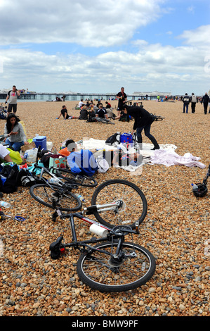 I partecipanti per rilassarvi sulla spiaggia dopo aver preso parte alla Londra a Brighton in Bicicletta REGNO UNITO Foto Stock