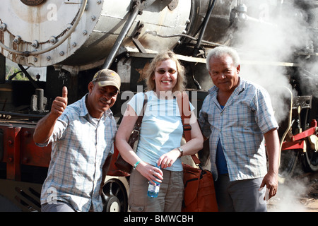 Cuba, Villa Clara, locomotiva cubano ingegnere e vigile del fuoco in posa con un turista Foto Stock