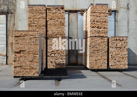 I pacchi di pannelli impilati nella parte anteriore del forno di essiccazione al mulino. Foto Stock