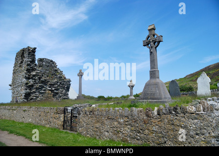 Croce celtica e resti di un monastero presso il cimitero sulla Bardsey Island, il Galles del Nord Foto Stock