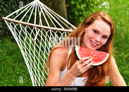 Donna con cocomero su una amaca Foto Stock