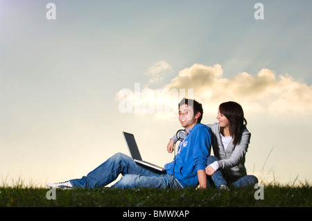 Coppia giovane utilizzando laptop all'aperto Foto Stock