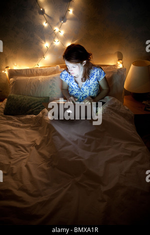 La donna a letto, a notte tarda su laptop Foto Stock
