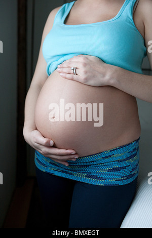La donna che mostra la gravidanza bump Foto Stock