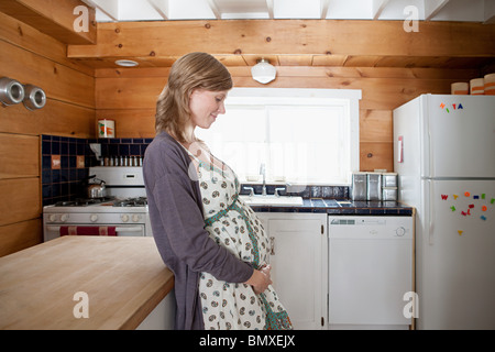 Donna incinta in cucina Foto Stock