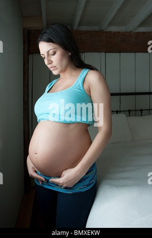 La donna che mostra la gravidanza bump Foto Stock