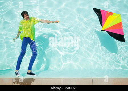 Uomo in piscina con kite Foto Stock