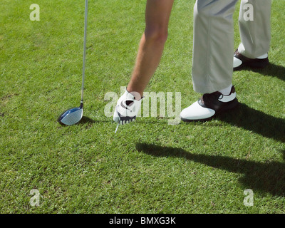 L'uomo giocando a golf, prelievo di sfera Foto Stock