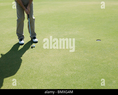 L'uomo giocando a golf, sul putting green Foto Stock