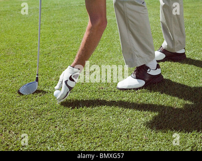 L'uomo giocando a golf, prelievo di sfera Foto Stock