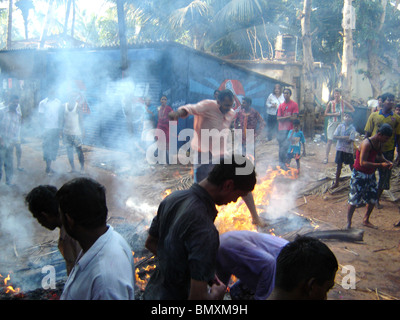 Holly festival in India con il fuoco jumping Foto Stock