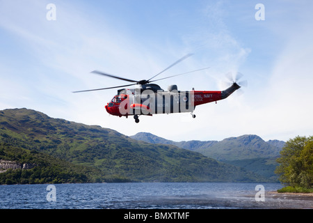 Royal Navy Sea King elicottero attaccato all'aria sea rescue sopra Loch Lomond, Scozia Foto Stock
