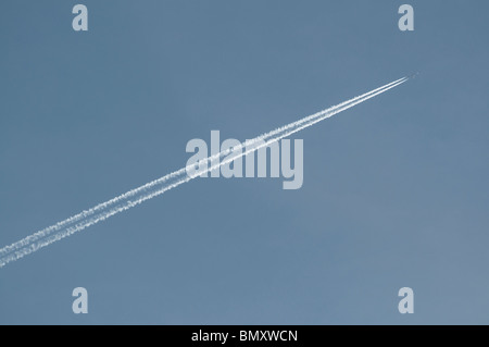 Un piano di lasciare i sentieri del vapore nel cielo. Foto Stock