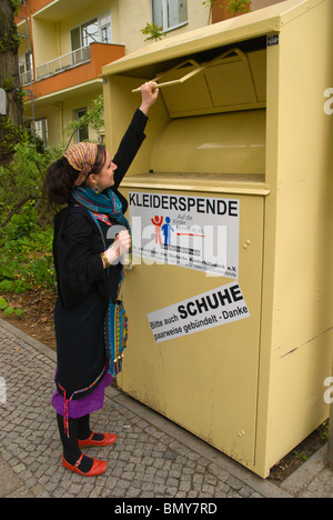 La donna nel suo fine 20s donando vestiti Berlin Germania Europa Foto Stock