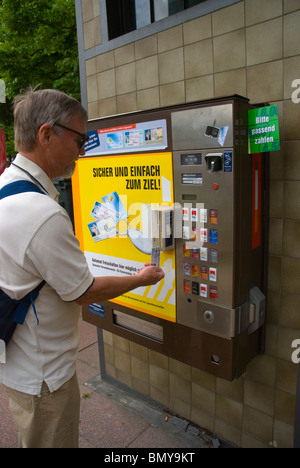 Uomo che utilizza la sua carta di identità per acquisto di sigarette da una macchina Berlin Germania Europa Foto Stock