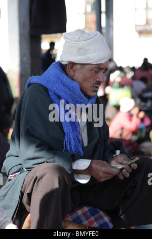 Un mercato trader conteggio attentamente il suo denaro a paro, Bhutan. Foto Stock