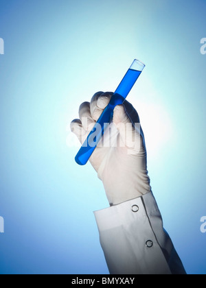 Un scienziato della mano trattiene una provetta riempita con un liquido di colore blu. Foto Stock
