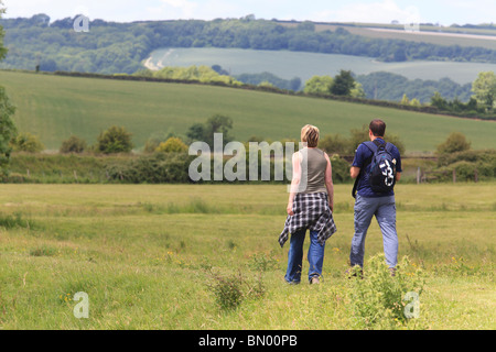 Giovane a piedi lungo un percorso il paese in un campo Foto Stock