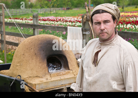 Festival del tempo dei tulipani Olanda Michigan negli Stati Uniti XVIII secolo Un fornaio in costume tradizionale in posa accanto al forno del pane caricato sul davanti ad alta risoluzione Foto Stock