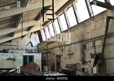 Attrezzature di vandalismo e degrado interno di una fabbrica abbandonata. Foto Stock