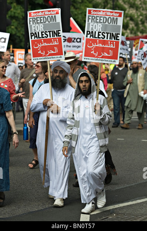 Due uomini vestiti in stile islamico abbigliamento portando cartelli durante una marcia di protesta contro il blocco israeliano della Striscia di Gaza 2010 Foto Stock