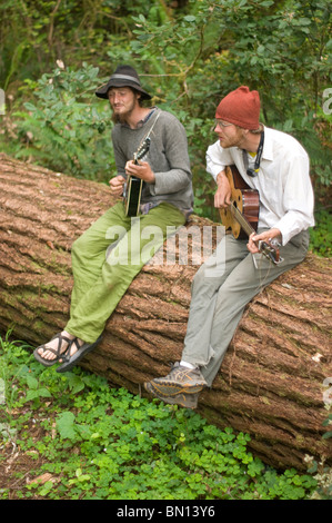 Camping musicisti suonare la chitarra e cantare una melodia in Redwoods Foto Stock